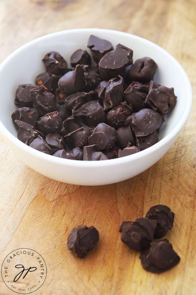 A white bowl filled with Chocolate Covered Chickpeas.