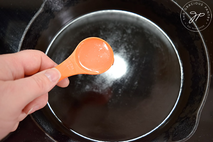 Adding oil to a cast iron skillet.