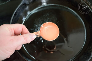 Adding oil to a cast iron skillet.
