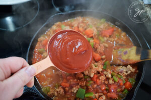 Adding ketchup to Healthy Turkey Sloppy Joes filling.