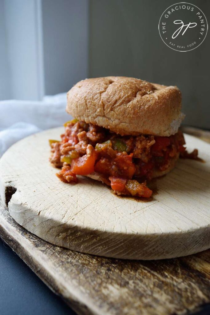 A single Healthy Turkey Sloppy Joe sits on two cutting boards next to a window,