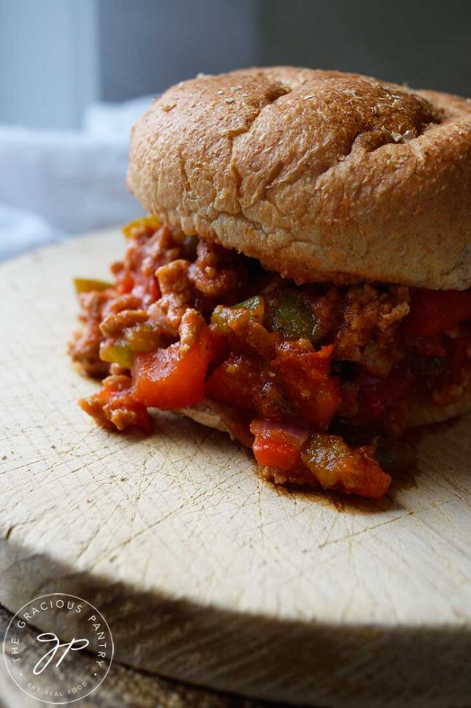 A closeup of a Healthy Turkey Sloppy Joe sandwich sitting on a cutting board.