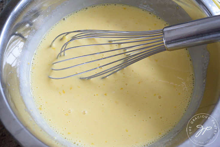 The batter for this recipe for lemon cream pit sits whisked and creamy in a mixing bowl.