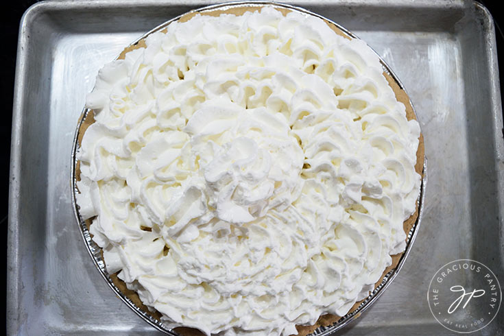 A chilled lemon cream pie topped with fresh whipped cream.