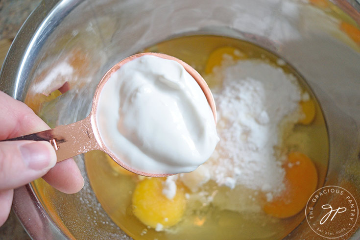 Adding yogurt to eggs and sweetener in a mixing bowl.