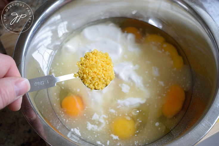 Adding fresh lemon zest to a bowl of ingredients for this recipe for lemon cream pie.