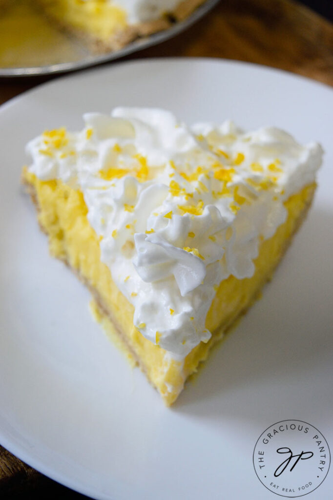 A single slice of pie from this Recipe For Lemon Cream Pie site on a white plate.