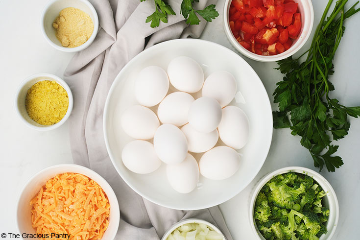 Gathered ingredients for this Vegetable Breakfast Tart Recipe in individual bowls on a white background.