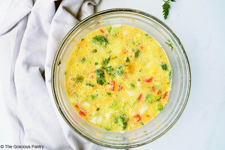 Vegetable Breakfast Tart batter mixed in a glass mixing bowl.