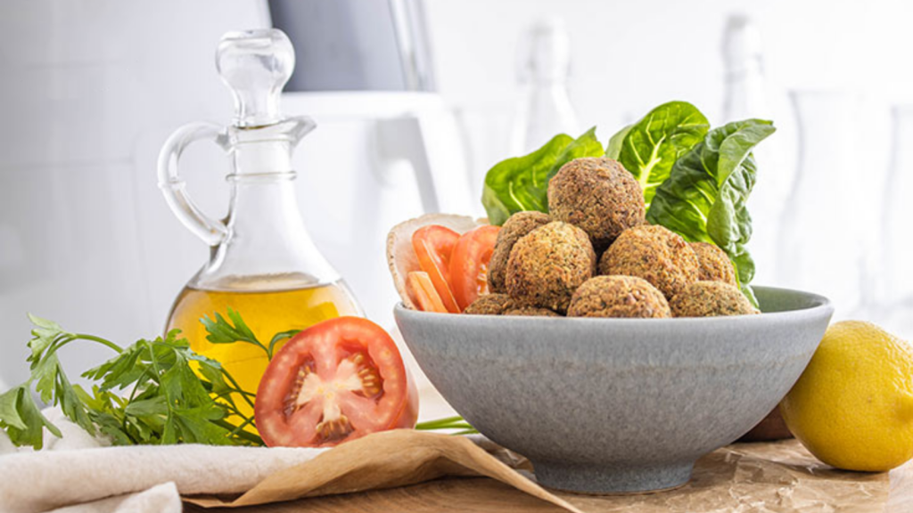 A gray bowl sits filled with air fryer falafel.