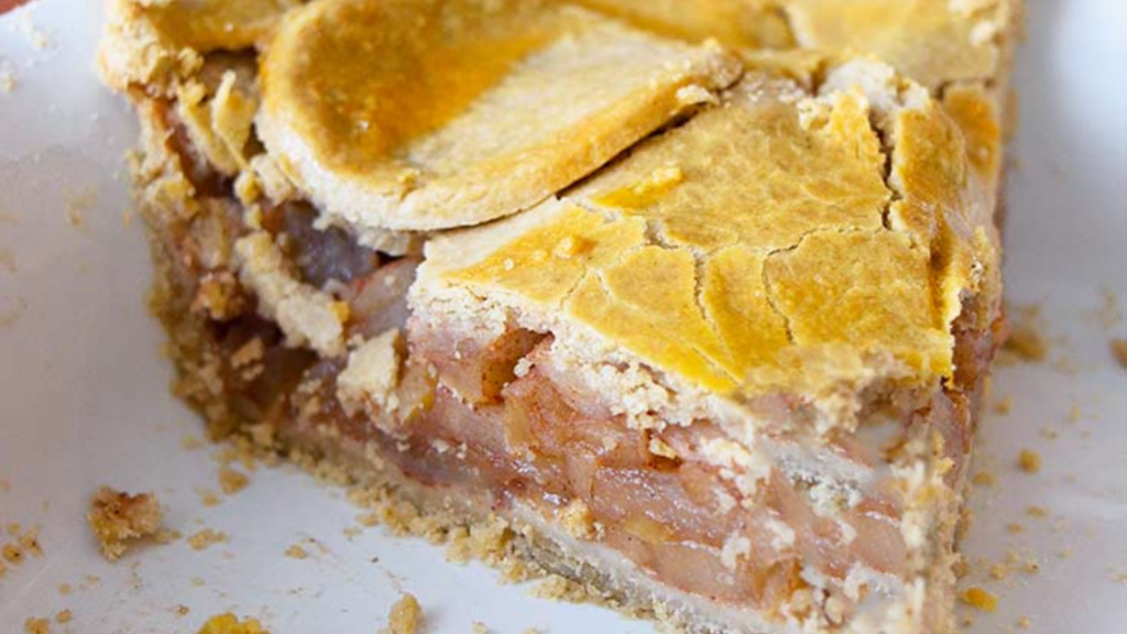 A single slice of apple pie in a white pie pan.