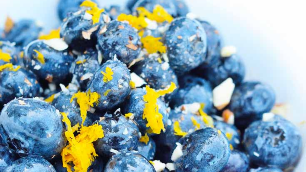 A closeup of almond blueberry salad with fresh lemon zest grated over the top.