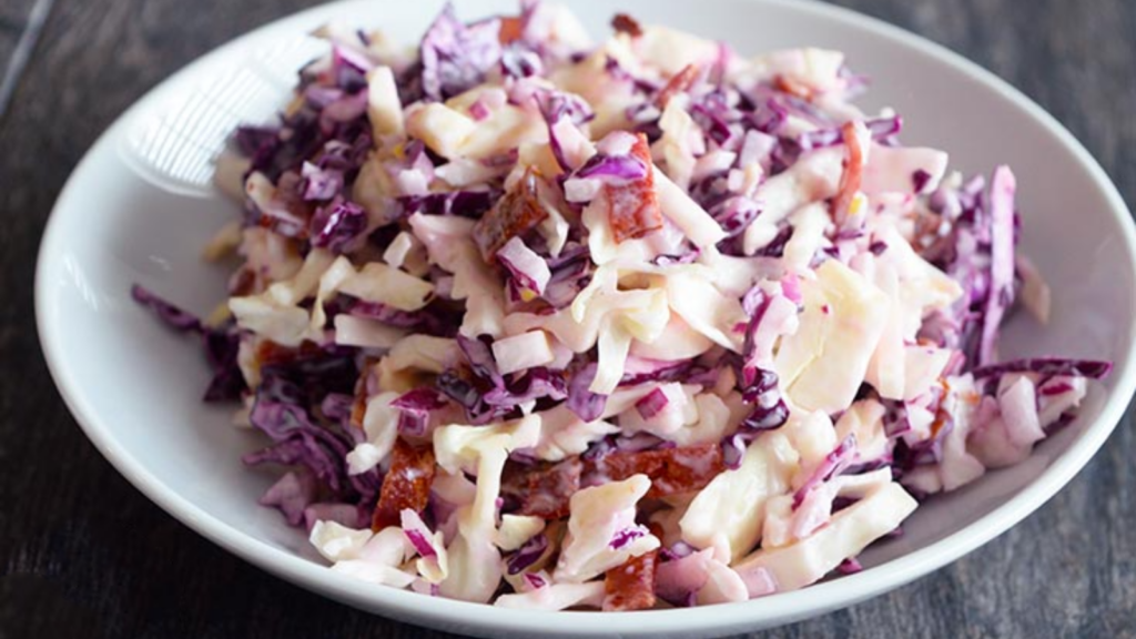 A white bowl filled with cabbage salad.