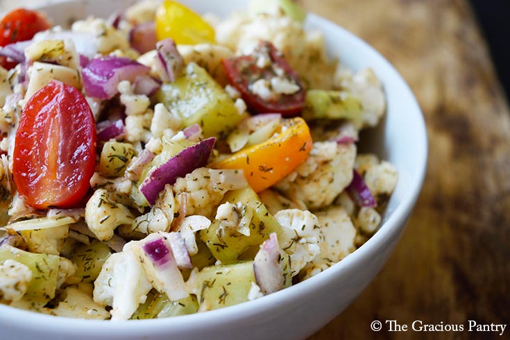 A white bowl filled with cauliflower salad.