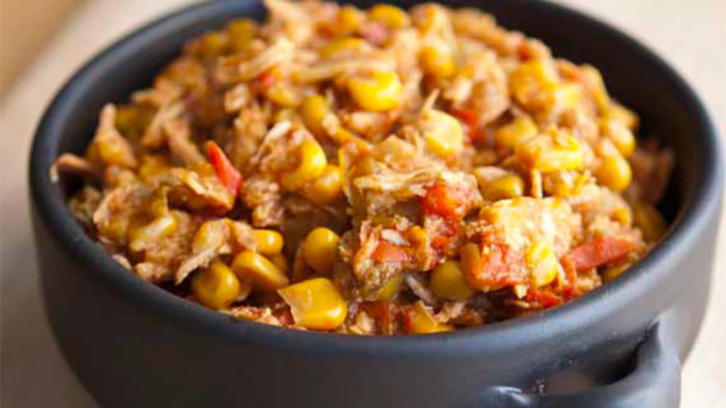 A black bowl is filled with chicken tortilla stew.