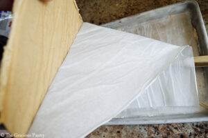 Peeling parchment off the back of the Chocolate Peanut Butter Frozen Yogurt Bark.