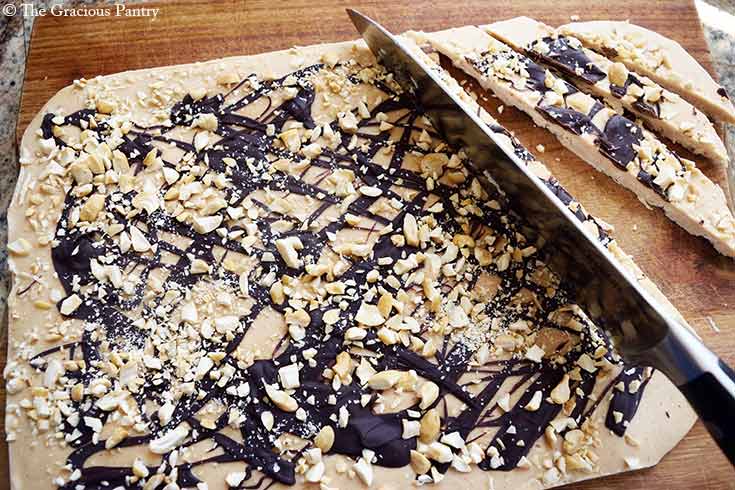 A knife cutting the Chocolate Peanut Butter Frozen Yogurt Bark into strips.