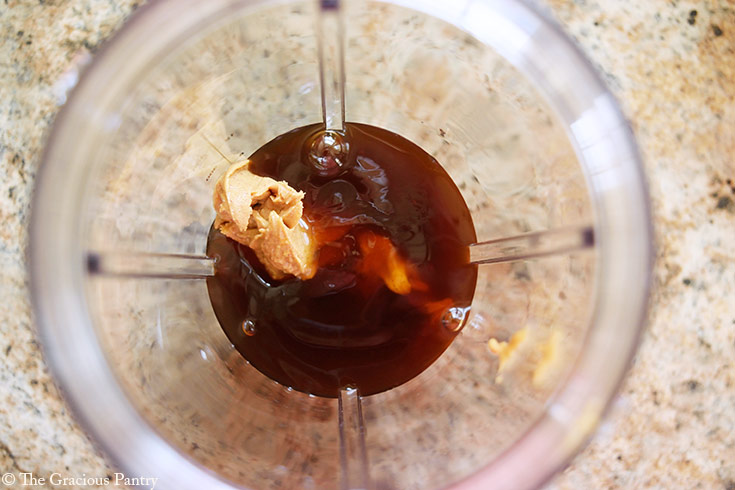 Sweetener added to peanut butter in a blender tumbler.