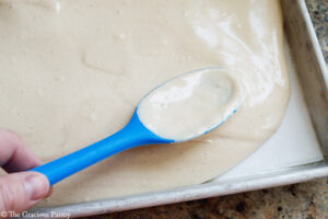 Spreading yogurt mixture over a parchment lined cookie sheet.