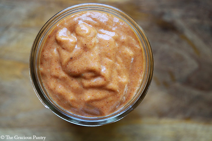 An overhead view of a small canning jar filled with Copycat Chick Fil A Honey BBQ Sauce.