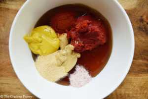 An overhead view of the ingredients for this Copycat Chick Fil A Honey BBQ Sauce sitting in a bowl, unmixed.