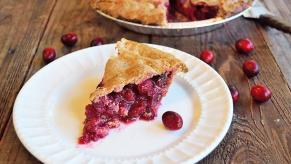 A slice of fresh cranberry pie sits on a white plate.