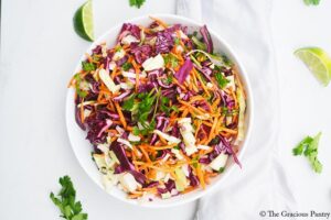An overhead view looking down into a white bowl filled with Mexican Coleslaw.