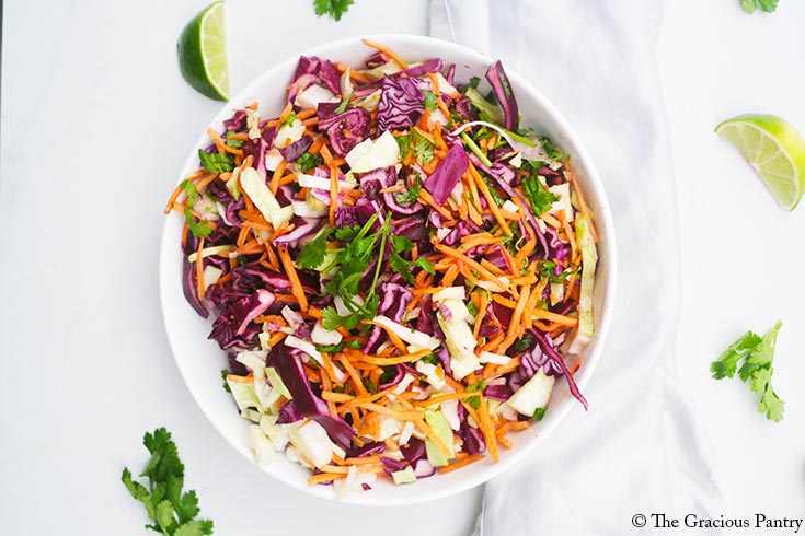 An overhead view looking down into a white bowl filled with Mexican Coleslaw.