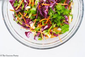 Mexican Coleslaw veggies mixed in a glass mixing bowl.