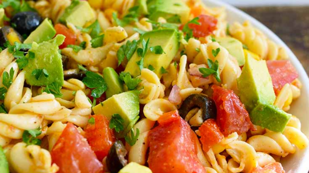 A closeup of a white bowl filled with Mexican Pasta Salad.