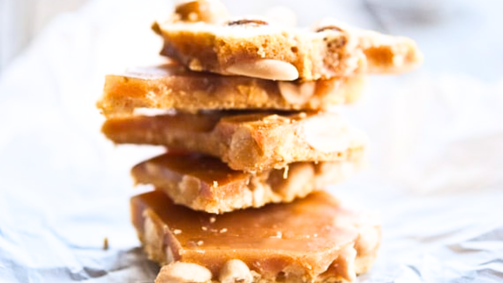 A stack of peanut brittle pieces on a white surface.