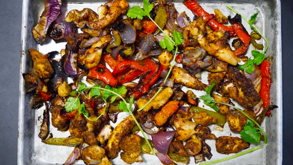 Sheep pan fajitas laying on a baking pan.