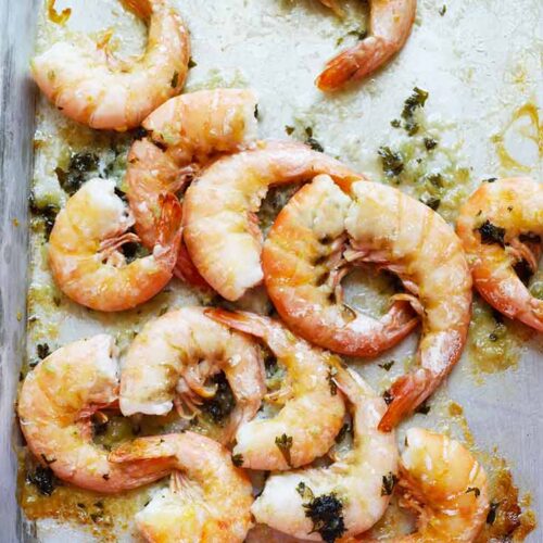 Sheet pan garlic butter shrimp laying on the sheet pan they were baked on.