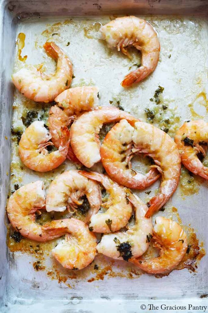 Sheet pan garlic butter shrimp laying on the sheet pan they were baked on.