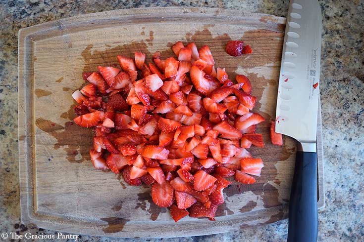 Chopped strawberries on a cutting board.