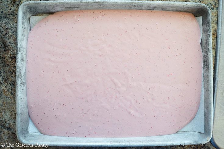 Blended Strawberry Frozen Yogurt Bark Recipe ingredients spread out over a parchment lined cookie sheet.