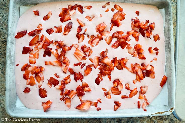 Chopped fresh strawberries sprinkled over the blended mixture on a parchment-lined cookie sheet.