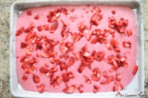 Strawberry Frozen Yogurt Bark, frozen and uncut, sitting in the sheet pan it was frozen in.
