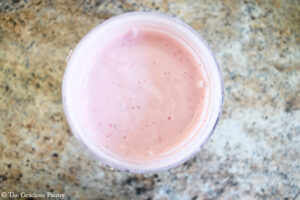 Blended Strawberry Frozen Yogurt Bark ingredients sitting in a blender tumbler.