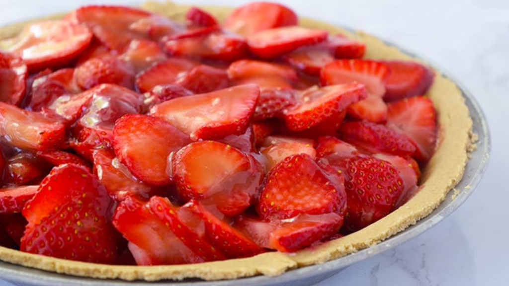 A fresh strawberry pie with glaze over the berries.