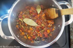 Bay leaves added to a pot of cooking veggies.