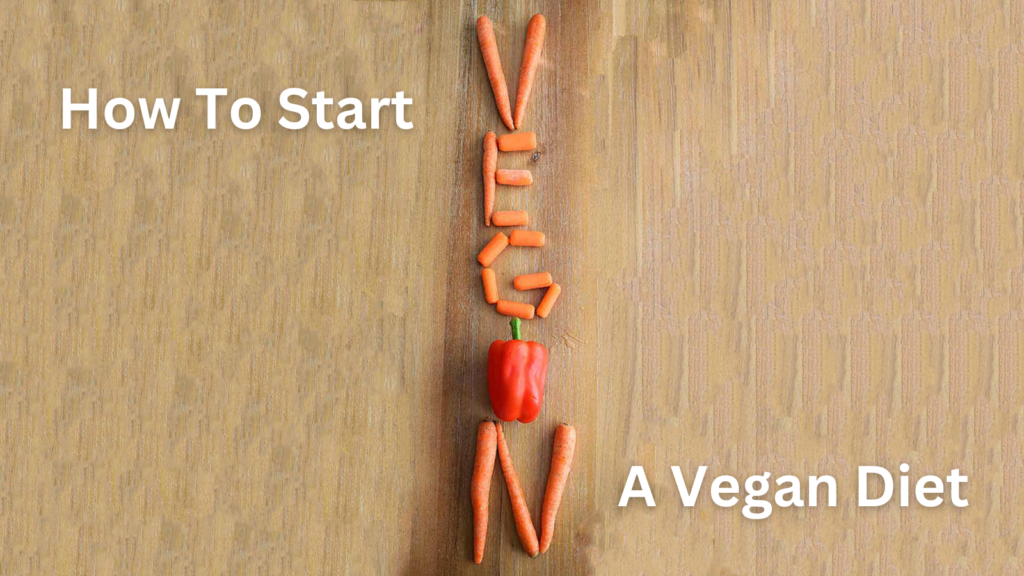 Carrots and a red bell pepper arranged on a wooden surface to spell the word, vegan.
