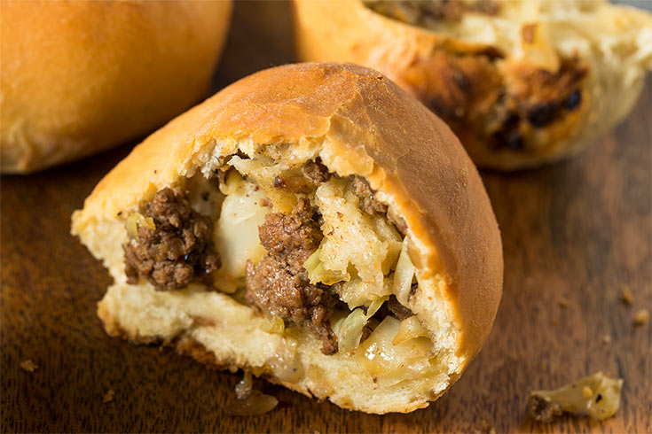An opened Runza laying on a wooden surface.
