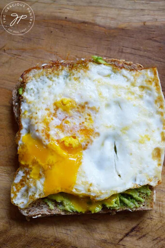 An overhead view of a piece of Avocado Toast With fried egg on top.