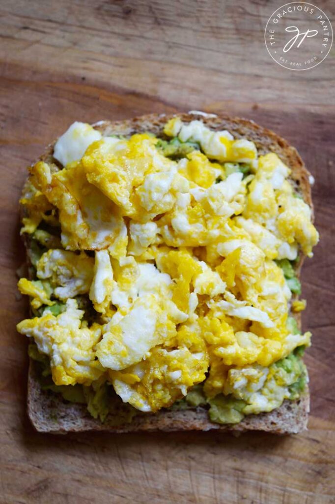 An overhead view of a slice of Avocado Toast With scrambled egg on top.
