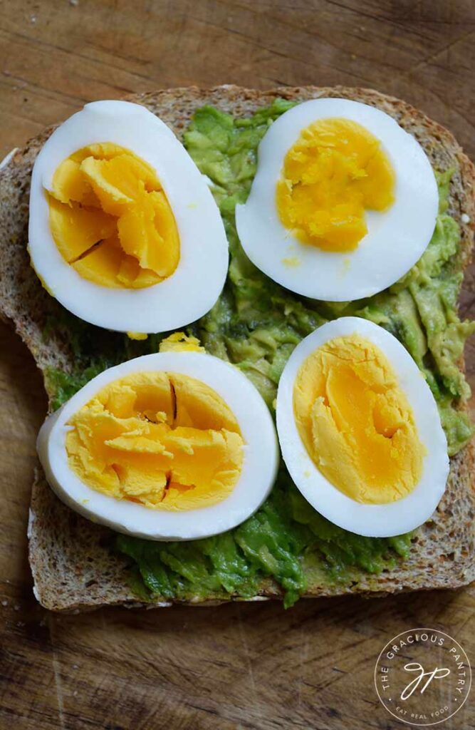 An overhead view of a slice of Avocado Toast With hard-boiled egg slices on top.