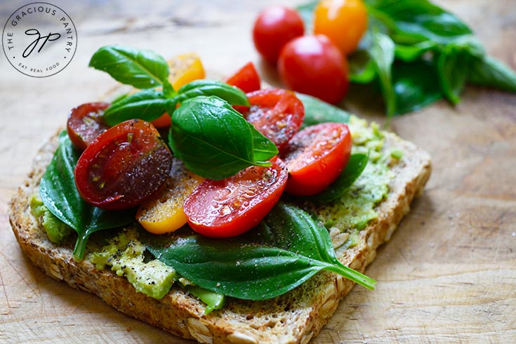 A side view of a single piece of Avocado Toast With Tomato.