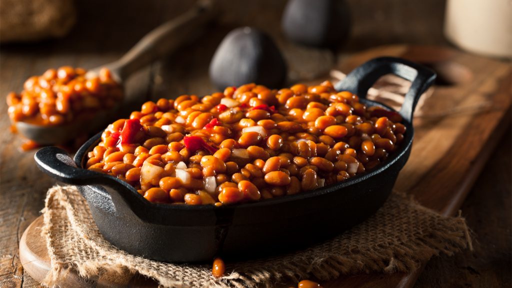 A black casserole dish filled with baked beans.