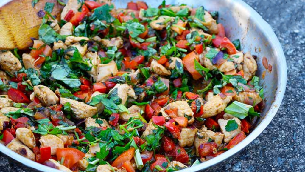 A skillet filled with bell pepper chicken.