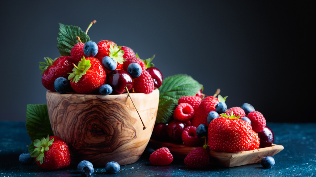 A wooden bowl filled with fresh berries.